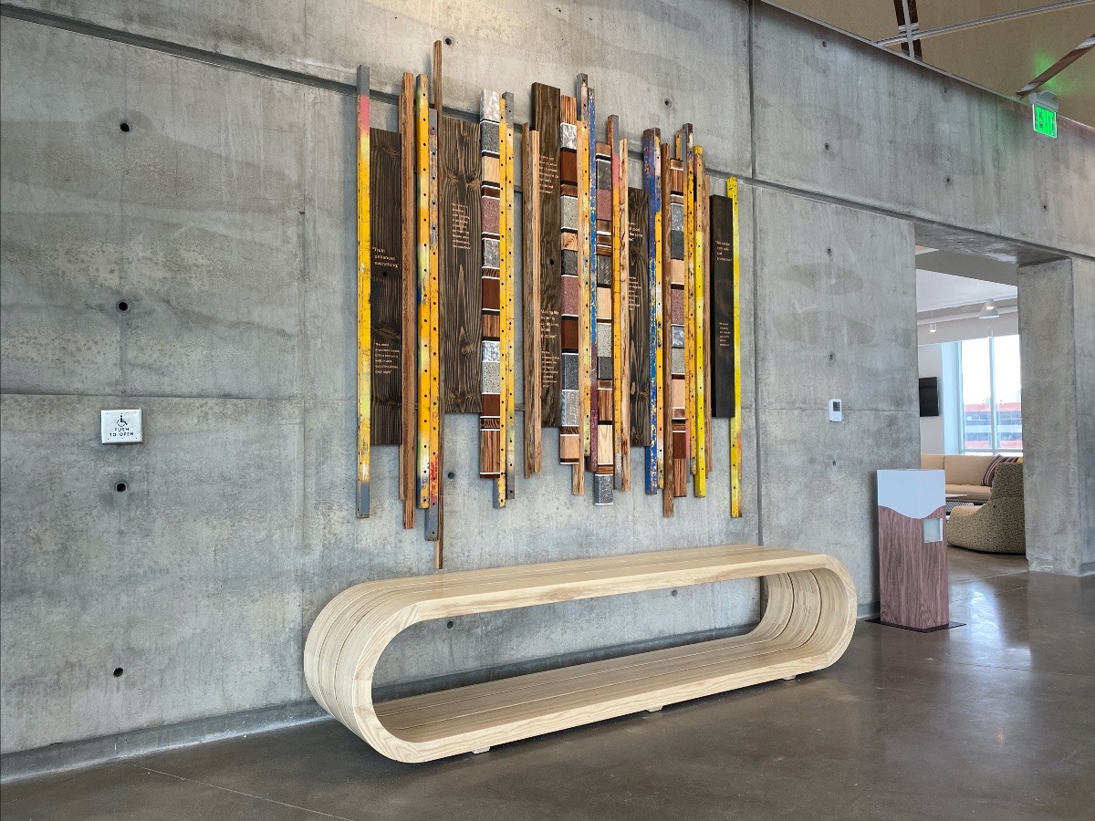 This eight-foot, blonde ash wood bench, called the Origins Bench, was designed in the Nordic style as an intentional nod to Jacobsen Construction Company founder Soren Jacobsen and his family’s Danish origins.  Hanging above the Origins Bench is a companion art piece — the Origins Wall Sculpture. Created from recycled materials from Jacobsen’s own warehouse yard, this piece represents the many layers of trust and collective Jacobsen expertise curated over ten successful decades of business.